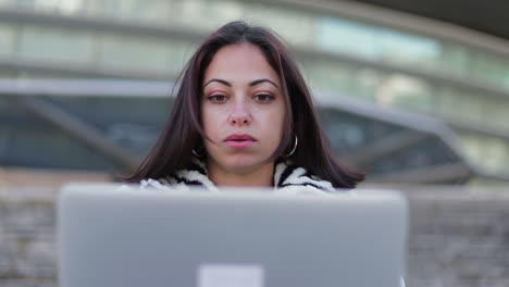 Exhausted-young-businesswoman-rubbing-face-and-closing-laptop